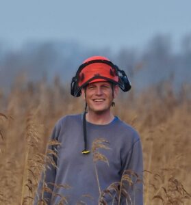 Matt Wilkinson, Wheatfen Warden, standing in a reedbed